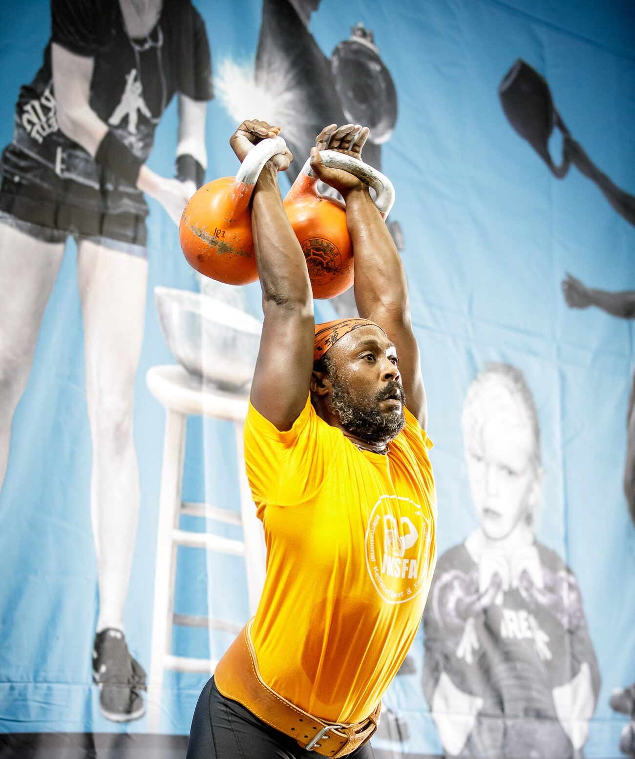 Irvin Charleston pressing two kettlebells overhead in competition